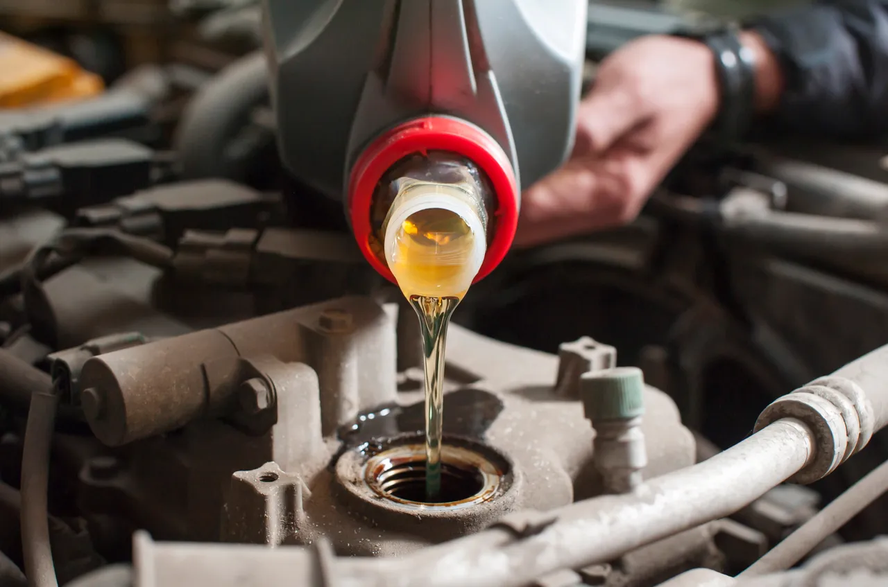 a-man-pours-oil-into-a-car-engine-close-up-2023-11-27-05-09-25-utc